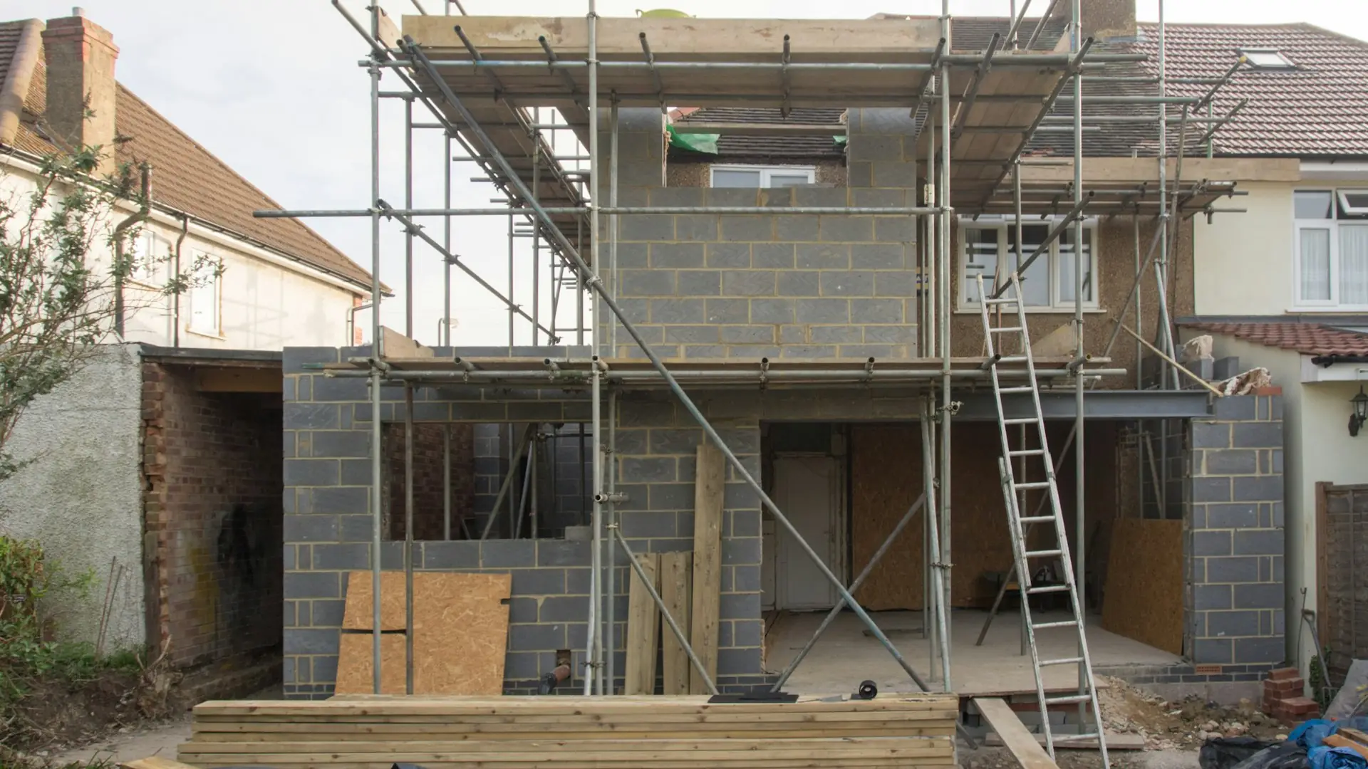 Vivienda en construcción con muros de bloque y andamio perimetral
